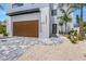 Modern home with wood garage door and paver driveway at 111 Gull Dr, Anna Maria, FL 34216