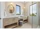 Elegant bathroom with double sinks, large mirrors, and modern light fixtures at 111 Gull Dr, Anna Maria, FL 34216
