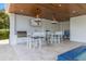 Outdoor kitchen with bar seating, grill, and stylish pendant lighting at 111 Gull Dr, Anna Maria, FL 34216