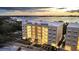 Exterior view of a modern condominium complex with well-lit stairways, showcasing elegant design and waterfront proximity at 280 Hidden Bay Dr # 203, Osprey, FL 34229