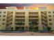 Beautiful yellow condo building featuring open-air hallways and staircases, as well as manicured landscaping at 280 Hidden Bay Dr # 203, Osprey, FL 34229