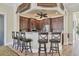 Charming kitchen area with dark wood cabinetry, modern appliances, granite countertops and bar seating at 280 Hidden Bay Dr # 203, Osprey, FL 34229