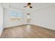 Bright bedroom with light wood floors, ceiling fan, balcony door, and double windows for ample natural light at 280 Hidden Bay Dr # 204, Osprey, FL 34229