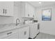 Well-equipped laundry room with a washer, dryer, and sleek cabinets at 280 Hidden Bay Dr # 302, Osprey, FL 34229