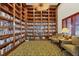 Cozy library with floor-to-ceiling bookshelves, comfortable seating, and natural light at 280 Hidden Bay Dr # 302, Osprey, FL 34229