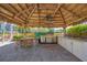Outdoor kitchen and entertainment area with stainless steel grill, seating, and tiki bar at 280 Hidden Bay Dr # 302, Osprey, FL 34229