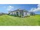 Home exterior showcasing a screened patio and well-manicured lawn at 100 Corserra Dr, Nokomis, FL 34275