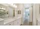 Elegant bathroom with double vanity and access to bedroom at 100 Corserra Dr, Nokomis, FL 34275