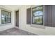 Front entry with dark brown door and window shutters at 100 Corserra Dr, Nokomis, FL 34275