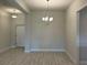 Spacious dining room features tile floors, modern chandelier, and seamless flow into the living area at 2600 Averland Loop, North Port, FL 34287