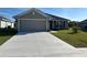 Exterior of a home with a smooth concrete driveway leading to a two car garage at 2600 Averland Loop, North Port, FL 34287