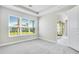 Bright bedroom featuring a large window offering backyard views, neutral walls, plush carpet and tray ceiling at 6098 Mesa Gln, Bradenton, FL 34203