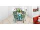 Charming dining area with a glass-top table and four teal chairs at 5641 Midnight Pass Rd # 902, Sarasota, FL 34242