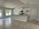 Bright kitchen featuring white cabinets, stainless steel appliances, and a granite countertop island at 2679 Englewood Rd, Venice, FL 34293