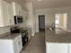 Well-equipped kitchen boasting white cabinets, granite countertops, and modern stainless steel appliances at 2679 Englewood Rd, Venice, FL 34293