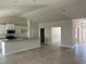 Open-concept living room with tile flooring, seamlessly connected to the kitchen area at 2679 Englewood Rd, Venice, FL 34293