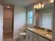 Bathroom with double sinks, granite counters, shower, and natural light at 855 Cumberland Rd, Venice, FL 34293