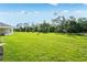 Expansive backyard featuring lush green grass and mature trees, perfect for outdoor activities and relaxation at 1580 Laurel Brook Ln, Port Charlotte, FL 33953