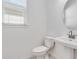 Bright half bathroom with a modern sink, toilet, and round mirror at 1580 Laurel Brook Ln, Port Charlotte, FL 33953