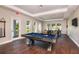 Bright game room with a pool table, wooden floors, and large windows providing natural light at 1580 Laurel Brook Ln, Port Charlotte, FL 33953