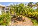 Landscaped backyard with lush tropical plants and trees at 915 Barclay Ct, Venice, FL 34293