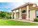 Front view of a beige house with a large covered entryway and lush landscaping at 1100 Pine Prairie Rd, Sarasota, FL 34240