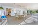 Spacious community room with dining sets, ceiling fans, and abundant natural light from surrounding windows at 3666 Bonaventure Ct, Sarasota, FL 34243