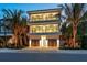 Luxury three-story home with modern design, double garage, and palm trees at 809 N Shore Dr, Anna Maria, FL 34216