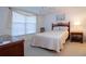 Cozy bedroom with wicker bed frame and window with blinds at 3780 Pinebrook Cir # 504, Bradenton, FL 34209