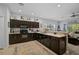 Modern kitchen with dark cabinets, island, and breakfast bar at 4737 Vignette Way, Sarasota, FL 34240