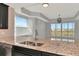 Kitchen with granite countertop and double sink, view to living room at 10520 Boardwalk Loop # 401, Lakewood Ranch, FL 34202