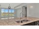 Kitchen with granite countertop and view of living room and water at 10520 Boardwalk Loop # 401, Lakewood Ranch, FL 34202