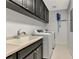Laundry room with washer, dryer, and utility sink at 10520 Boardwalk Loop # 401, Lakewood Ranch, FL 34202