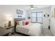 Bedroom featuring a bed with gray headboard, end table, ceiling fan, and window at 4410 Fairways Blvd # 406, Bradenton, FL 34209