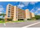 Multi-story condominium building with parking and landscaping under a bright blue sky at 4410 Fairways Blvd # 406, Bradenton, FL 34209