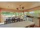 Inviting outdoor kitchen with grill, dining area and view of pool and landscaping at 4410 Fairways Blvd # 406, Bradenton, FL 34209