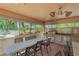 Inviting outdoor kitchen with grill, dining area and view of pool and landscaping at 4410 Fairways Blvd # 406, Bradenton, FL 34209