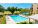 Relaxing community pool with poolside seating, umbrellas, and views of the lake and golf course at 4410 Fairways Blvd # 406, Bradenton, FL 34209