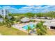 A gorgeous aerial view of the community pool, clubhouse, and surrounding palm trees and landscaping at 4410 Fairways Blvd # 406, Bradenton, FL 34209