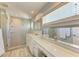 Modern bathroom with a walk-in shower, double vanity, and a large mirror at 2314 Avenue B, Bradenton Beach, FL 34217