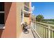 Relaxing condo balcony features seating for two with sunny views of mature trees and calm waters at 611 Riviera Dunes Way # 108, Palmetto, FL 34221
