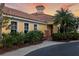 Exterior view of a building with a terracotta roof, yellow walls, and lush tropical landscaping at 611 Riviera Dunes Way # 108, Palmetto, FL 34221