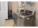 Well-equipped laundry room featuring modern washer and dryer, ample storage and sleek tile flooring at 611 Riviera Dunes Way # 108, Palmetto, FL 34221