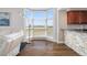 Living room featuring a bay window and hardwood floors, showcasing an open layout to the kitchen bar at 611 Riviera Dunes Way # 108, Palmetto, FL 34221