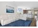 Open-concept living room boasts a white sectional sofa and water view at 611 Riviera Dunes Way # 108, Palmetto, FL 34221
