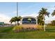 Community sign for Riviera Dunes Marina & Restaurant surrounded by green lawn and palm trees at 611 Riviera Dunes Way # 108, Palmetto, FL 34221