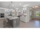 Open kitchen with white cabinets and large island at 5565 Long Shore Loop, Sarasota, FL 34238