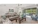 Open living space featuring a sectional sofa and views of the backyard pool at 5565 Long Shore Loop, Sarasota, FL 34238
