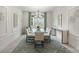 Elegant dining room with a glass-top table and contemporary light fixture at 5565 Long Shore Loop, Sarasota, FL 34238