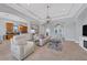 Open and bright living room with a view of the kitchen and access to the pool area at 13853 Siena Loop, Lakewood Ranch, FL 34202